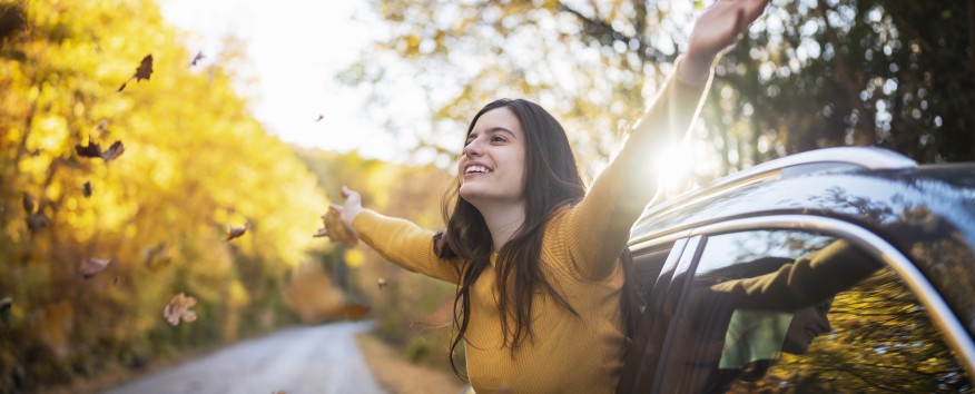 Lady with arms up in the leaves