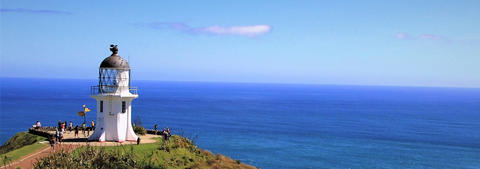 The Cape Reinga Lighthouse over looking the ocean with a blue sky