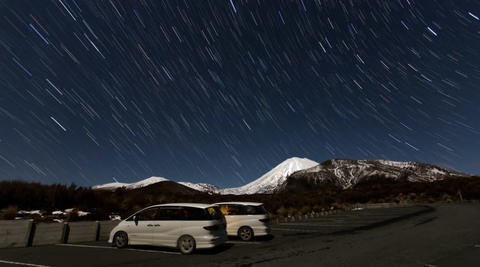 Two mode campervans parked on a snowy mountain at night