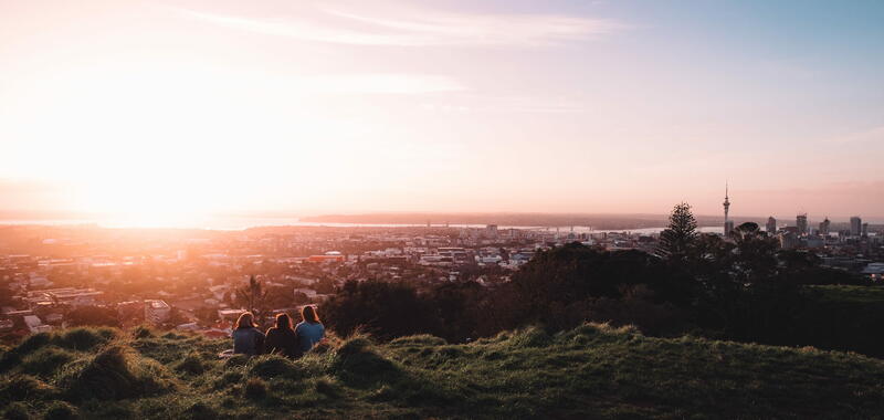 Group of friends watching Auckland city sunset 