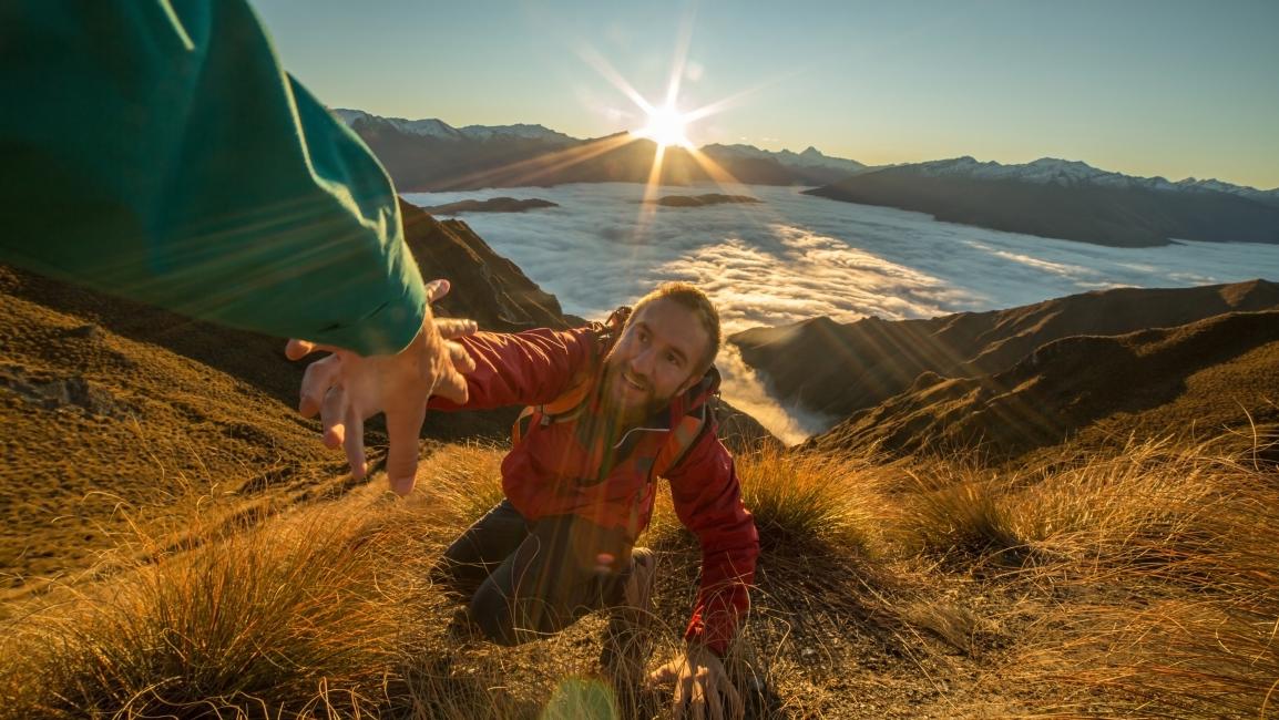 Helping man up mountain